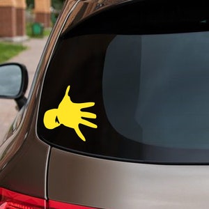May include: A yellow hand silhouette sticker on a car window.