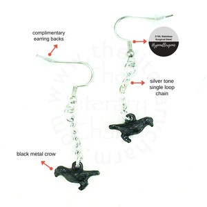 May include: A pair of silver tone earrings with black metal crow charms hanging from a single loop chain. The earrings are made of 316L stainless steel and are hypoallergenic.