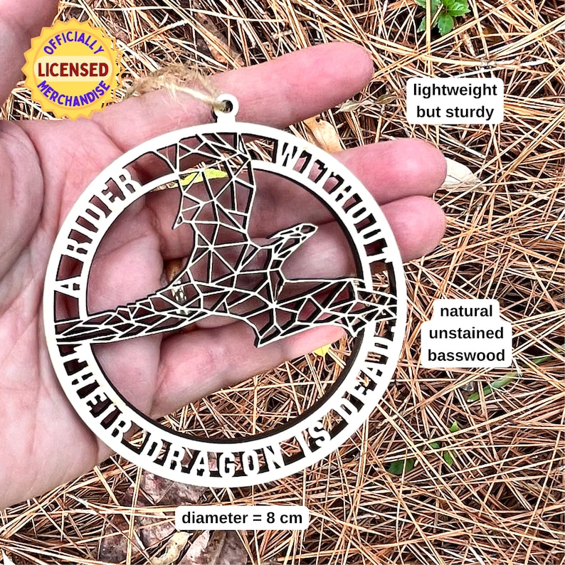 geometric dragon laser cut wood ornament held on palm of hand for scale
