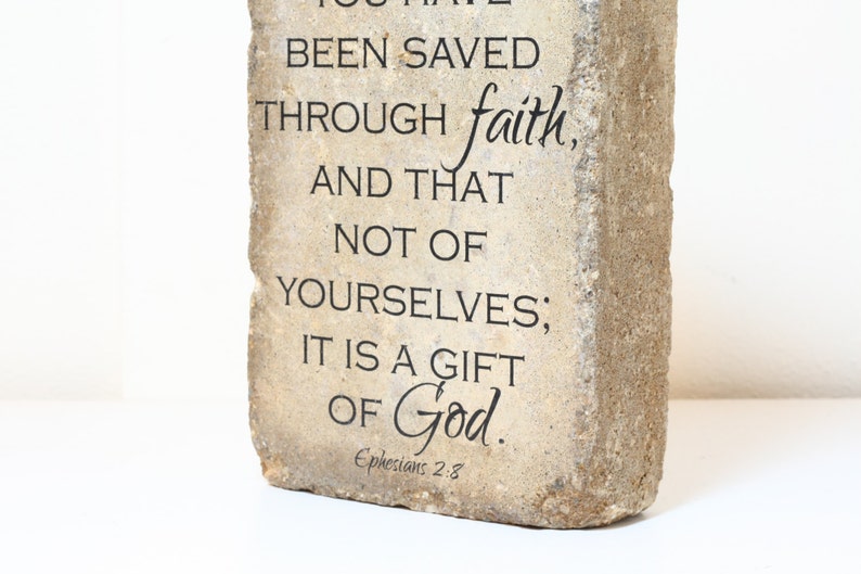 May include: A stone plaque with the text "BEEN SAVED THROUGH faith, AND THAT NOT OF YOURSELVES; IT IS A GIFT OF God." and the scripture reference "Ephesians 2:3".