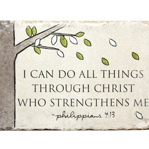 May include: A stone plaque with a hand-drawn tree branch with green and white leaves. The plaque has the text "I can do all things through Christ who strengthens me - Philippians 4:13"
