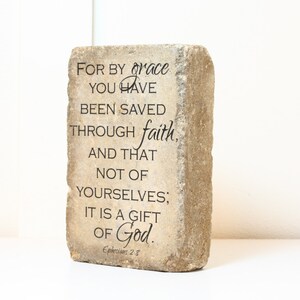 May include: A stone block with the text "FOR BY grace YOU HAVE BEEN SAVED THROUGH faith, AND THAT NOT OF YOURSELVES; IT IS A GIFT OF God. Ephesians 2:8"