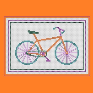 May include: Cross-stitch design of a bicycle in orange, teal, and purple. The bicycle is centered on a white background, framed by a purple and green border. The background is a solid orange.
