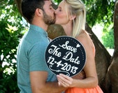 Round save the date chalkboard sign.