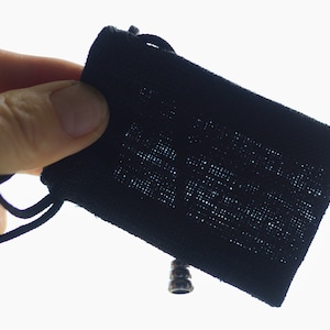 May include: A black drawstring pouch with a silver metal toggle closure.