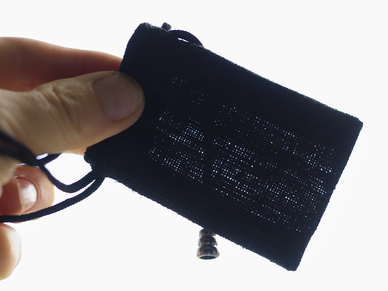 May include: A black drawstring pouch with a silver metal toggle closure.