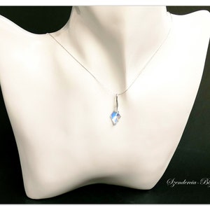May include: A silver chain necklace with a clear crystal pendant. The pendant is faceted and has a slight iridescent shimmer.