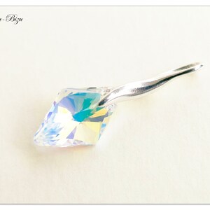 May include: A silver pendant with a clear iridescent crystal. The crystal is faceted and has a rainbow effect. The pendant is on a white background.