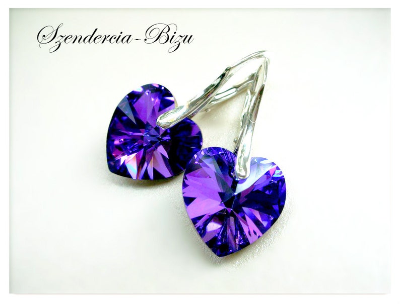 May include: A pair of silver earrings with purple heart-shaped crystals.