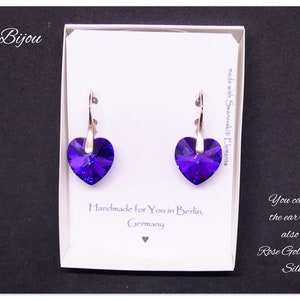 May include: A pair of silver heart-shaped earrings with purple crystals. The earrings are made with Swarovski elements and are handmade in Berlin, Germany. You can also buy the earrings in rose gold plated silver.