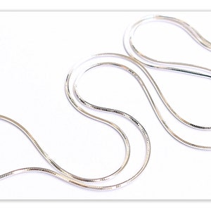 May include: A silver snake chain necklace. The chain is made of small, interlocking links that create a smooth, flowing look.