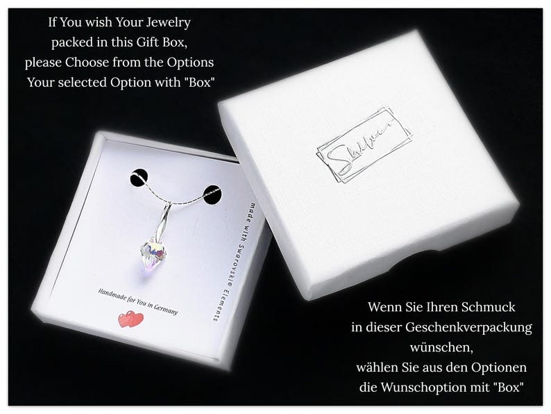 May include: A white gift box with a silver necklace inside. The necklace has a clear crystal pendant. The box has the text "If You wish Your Jewelry packed in this Gift Box, please Choose from the Options Your selected Option with "Box"" and "Handmade for You in Germany" printed on it.