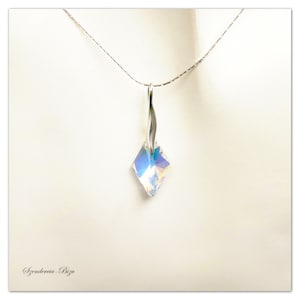 May include: A silver chain necklace with a clear iridescent crystal pendant in a square shape.