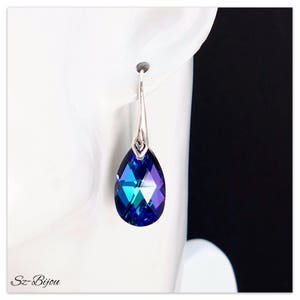 Pu&ograve; includere: Orecchini pendenti in argento con un cristallo blu iridescente a forma di lacrima.