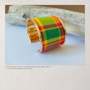 May include: A gold cuff bracelet with a red, green, yellow and brown plaid fabric band. The bracelet is made by La Touch Turkoiz.