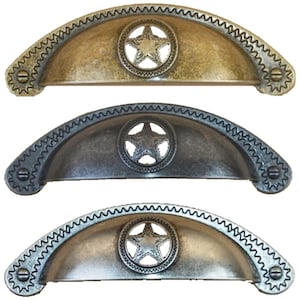May include: Three antique-style cabinet pulls with a star design in the center. The pulls are in three different finishes: brass, pewter, and nickel.