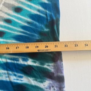 Puede incluir: Primer plano de una tela de te&ntilde;ido anudado azul y blanca con una regla que mide 50,8 cm. La tela tiene un degradado de colores azul, blanco y verde.