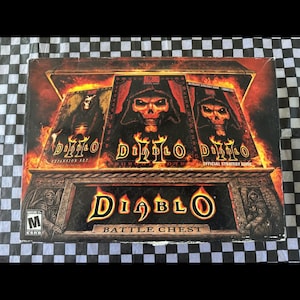 May include: Diablo Battle Chest box set featuring Diablo game artwork. The box has a black background with the Diablo logo and images of skulls and flames. The set includes the game, expansion set, and strategy guide.