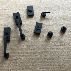 Puede incluir: Un juego de herrajes para puertas de color negro, que incluye una manija de puerta, un pomo de puerta y un pestillo. Los herrajes est&aacute;n hechos de metal y tienen un acabado mate.