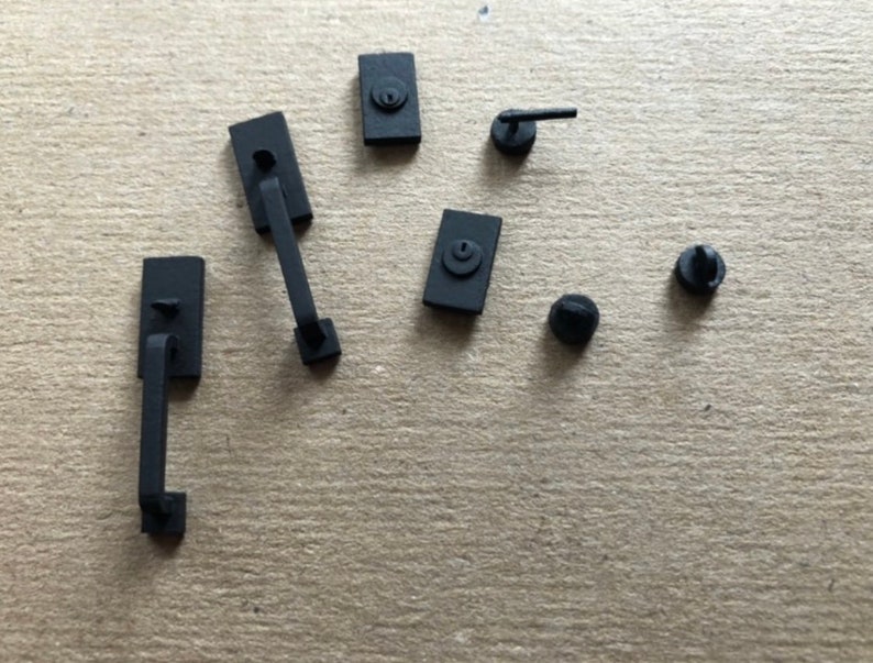 Puede incluir: Un juego de herrajes para puertas de color negro, que incluye una manija de puerta, un pomo de puerta y un pestillo. Los herrajes est&aacute;n hechos de metal y tienen un acabado mate.