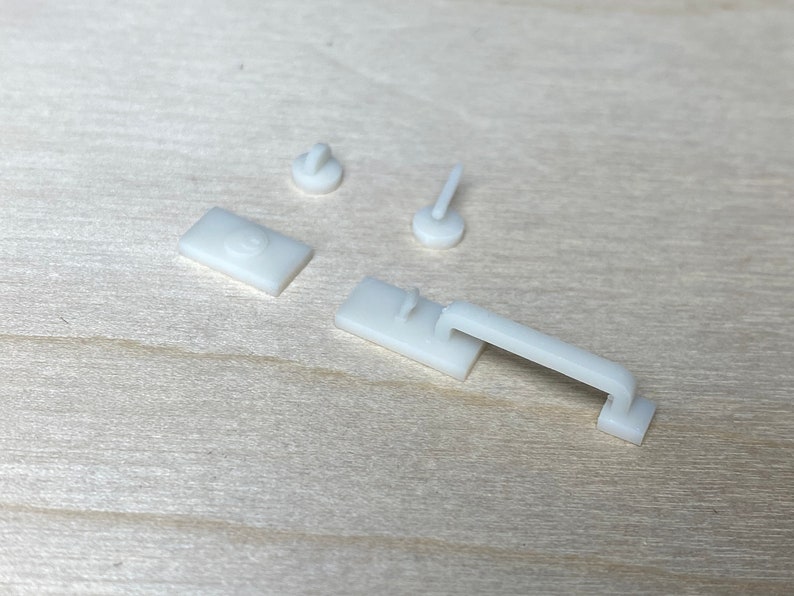 Puede incluir: Cuatro piezas de herrajes de puerta en miniatura de pl&aacute;stico blanco, que incluyen una manija de puerta, un pomo de puerta y dos topes de puerta.