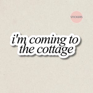 May include: A white sticker with the phrase "I'm coming to the cottage" in a black, cursive font. The sticker has a white border and is on a beige background. A pink circle with the word "stickers" is in the upper right corner.