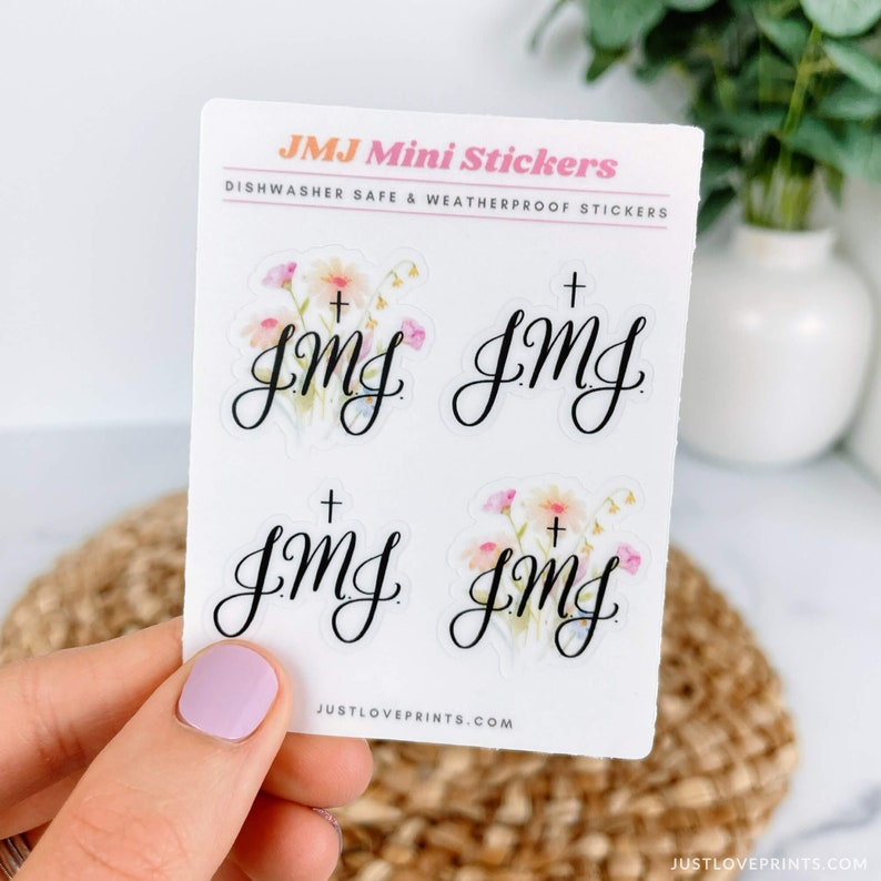 Two clear JMJ with cross stickers and two JMJ with flowers on a sticker sheet.