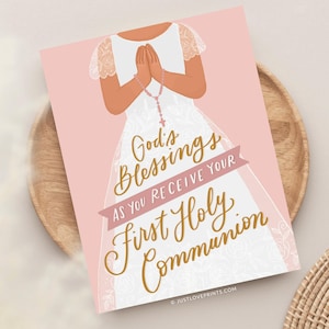 May include: A rectangular print on a light pink background featuring an illustration of a person in a white dress with lace sleeves, hands clasped in prayer holding a rosary. The text reads God's Blessings AS YOU RECEIVE YOUR First Holy Communion.