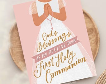 May include: A rectangular print on a light pink background featuring an illustration of a person in a white dress with lace sleeves, hands clasped in prayer holding a rosary. The text reads God's Blessings AS YOU RECEIVE YOUR First Holy Communion.