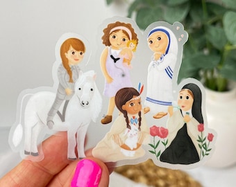 May include: A clear sticker featuring four illustrated figures: a person in armor riding a white horse, a person in a light purple dress with a stethoscope, a person in a white and blue habit, and a person in a black habit holding red roses.