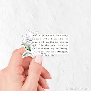 May include: A rectangular sticker featuring a black text quote that reads: Jesus gives me, at every moment, what I am able to bear and nothing more, and if in the next moment He increases my suffering, He also increases my strength. St. Thérèse of Lisieux.