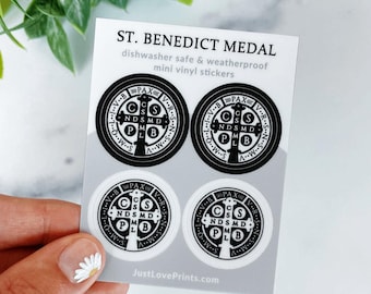 May include: A sheet of four mini vinyl stickers featuring the St. Benedict Medal design. Two stickers are black with white details, and two are white with black details. The text reads ST. BENEDICT MEDAL, dishwasher safe & weatherproof, and JustLovePrints.com.