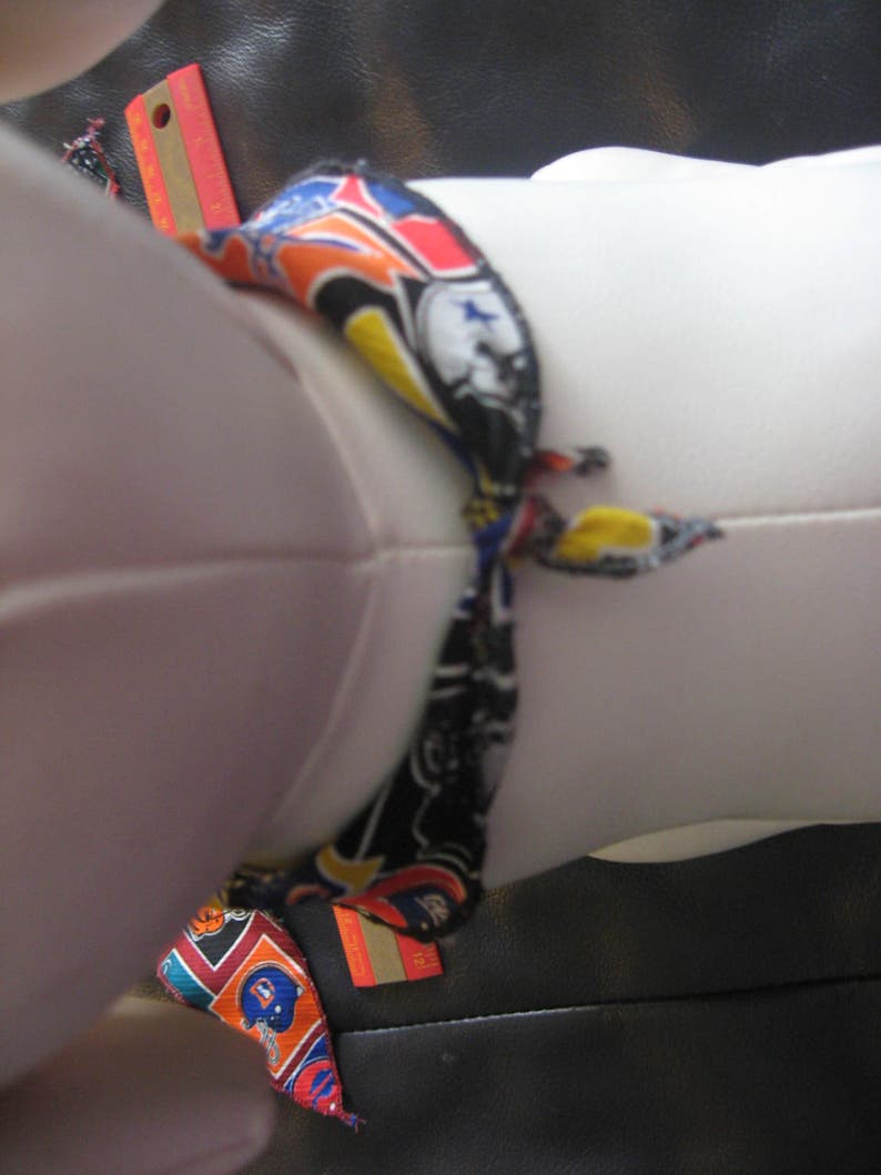 Peut inclure: Un mannequin en tissu blanc avec une &eacute;charpe &agrave; motifs color&eacute;s nou&eacute;e autour du cou. L'&eacute;charpe a un fond noir avec des accents orange, jaune, bleu et rouge. L'&eacute;charpe est nou&eacute;e en un n&oelig;ud &agrave; l'avant du cou du mannequin.