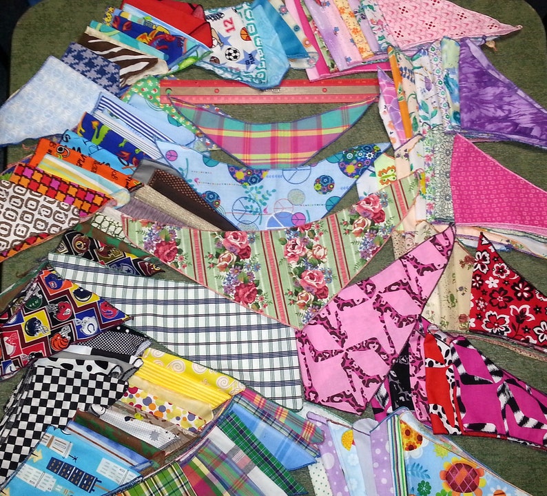 Peut inclure: Une collection de bandanas en tissu color&eacute;s avec diff&eacute;rents motifs, notamment des imprim&eacute;s g&eacute;om&eacute;triques, floraux et animaliers. Les bandanas sont dispos&eacute;s en &eacute;ventail sur une surface verte.