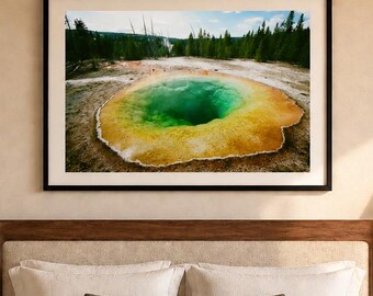May include: A bedroom featuring a low-profile wooden platform bed with a beige textured quilt, two matching wooden nightstands, and wall-mounted lamps. Above the bed hangs a framed landscape photograph of a vibrant green geothermal pool.