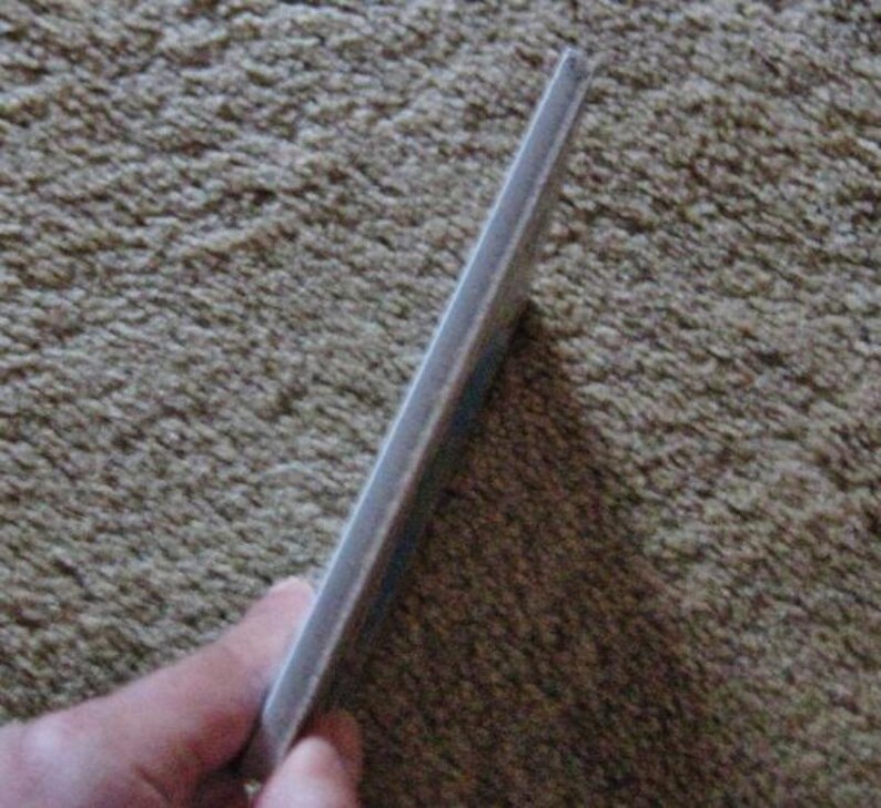 May include: A close-up of the edge of a white book with a slightly textured cover.