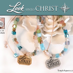 May include: Two delicate bracelets with square beads in shades of blue, green, and brown. Each bracelet has a gold charm with the words "Look Unto Christ" and the scripture "Doubt Not-Fear Not".
