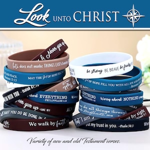 May include: A stack of colorful silicone wristbands with inspirational quotes from the Bible. The bands are in various colors, including blue, brown, and white, with white lettering. The text "Look Unto Christ" is at the top.
