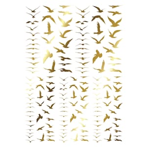 May include: A sheet of metallic gold temporary tattoos featuring numerous small bird silhouettes in various flight positions. The designs include birds with wings spread wide, soaring, and gliding, arranged in a repeating grid pattern across the surface.