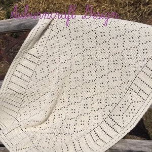 May include: A crocheted blanket with a delicate, intricate pattern in a cream color. The blanket is made with a fine yarn and has a soft, airy texture.