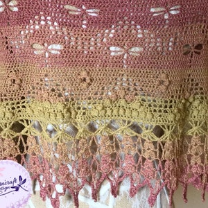 A delicate shawl featuring dragonflies and a intricate lace edge, displayed on a mannequin so the edge is featured.