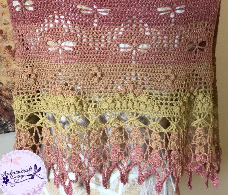 A delicate shawl featuring dragonflies and a intricate lace edge, displayed on a mannequin so the edge is featured.