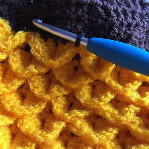 Crochet hat looking like sunflower. yellow petals created using crocodile stitch