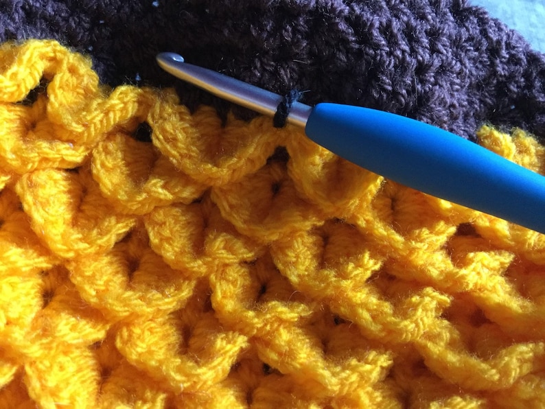 Crochet hat looking like sunflower. yellow petals created using crocodile stitch