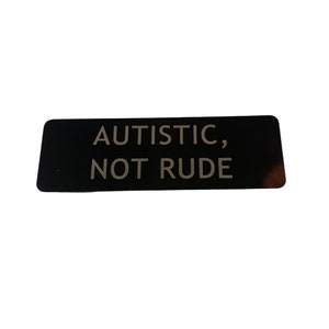 May include: Black rectangular sticker with the text "AUTISTIC, NOT RUDE" in white.