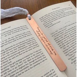 May include: A copper bookmark with a quote about marriage engraved on it. The quote reads "Marriage is like a good book full of twists and turns, and plenty of pages on each anniversary."