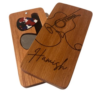 May include: A wooden guitar pick holder with a cutout for a pick and a slot for a guitar pick. The holder is engraved with the name "Hamish" and a line drawing of a guitar.