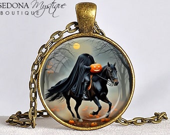 May include: Bronze-toned pendant necklace featuring a round image of the Headless Horseman riding a black horse through a spooky forest. The pendant has a chain and a decorative bail. The words "Headless Horseman" are at the bottom.