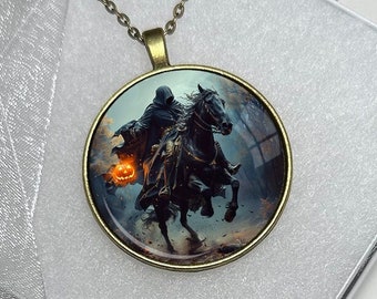 May include: A round pendant necklace with a bronze chain. The pendant features a spooky image of a cloaked figure on a horse, holding a jack-o'-lantern. The pendant is 40mm in diameter and is displayed in a white box.