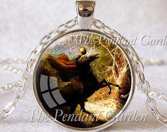 May include: Silver-toned pendant necklace featuring a circular pendant with an image of a rider on a black horse, set against a forest backdrop. The text "The Pendant Garden" is printed on the pendant. The chain is also silver.